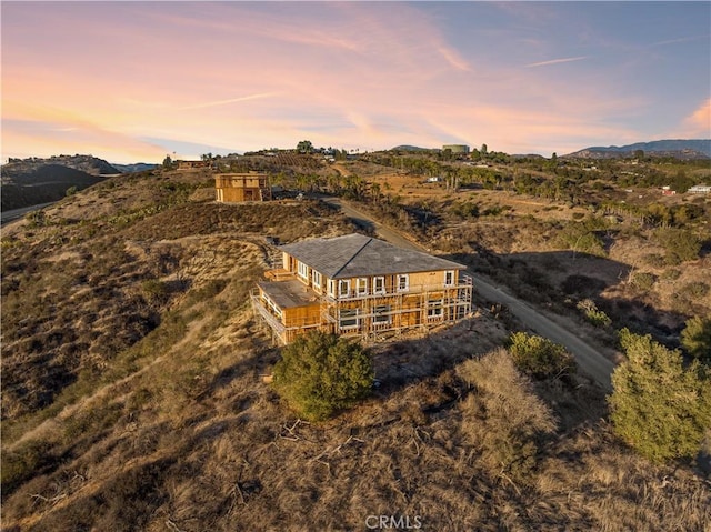 aerial view at dusk featuring a mountain view