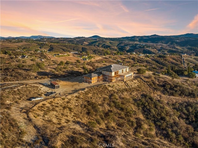 aerial view at dusk featuring a mountain view