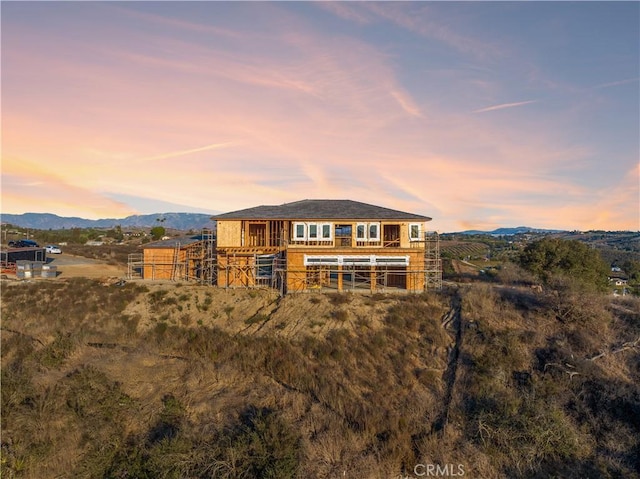 back house at dusk featuring a mountain view