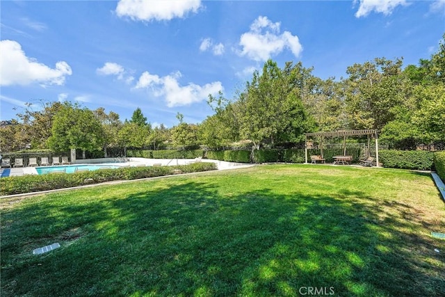 view of yard with a fenced in pool and a pergola