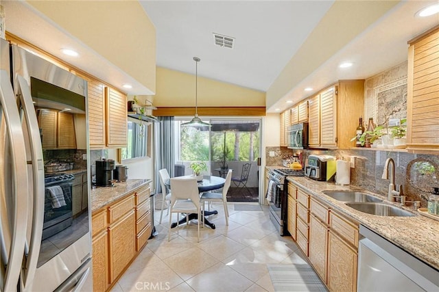 kitchen with sink, appliances with stainless steel finishes, tasteful backsplash, decorative light fixtures, and vaulted ceiling