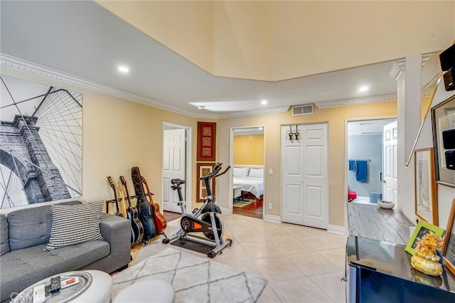 exercise room with light tile patterned floors and crown molding