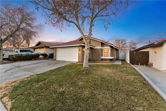 ranch-style house featuring a garage and a lawn