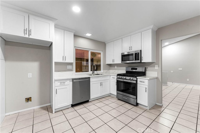 kitchen with white cabinets, appliances with stainless steel finishes, sink, and light tile patterned floors