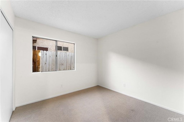 carpeted empty room with a textured ceiling