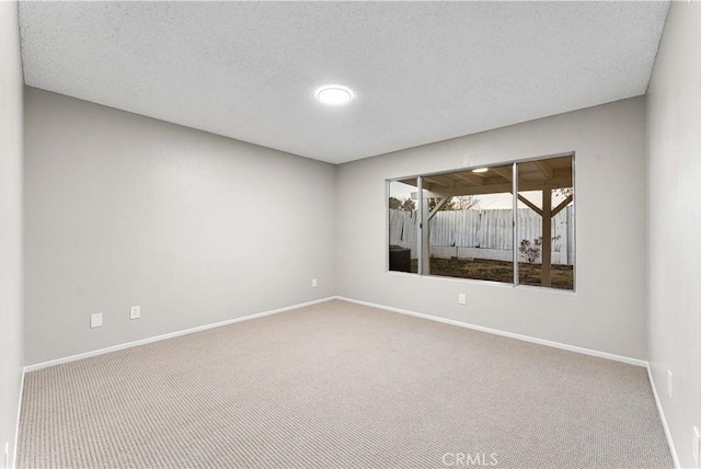 spare room with a textured ceiling and carpet flooring