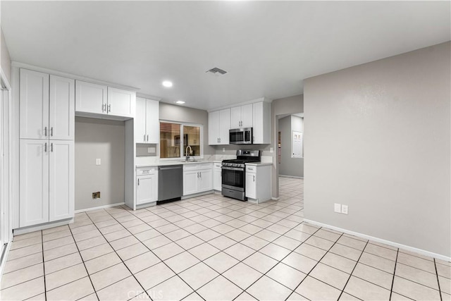 kitchen featuring sink, white cabinetry, appliances with stainless steel finishes, and light tile patterned flooring