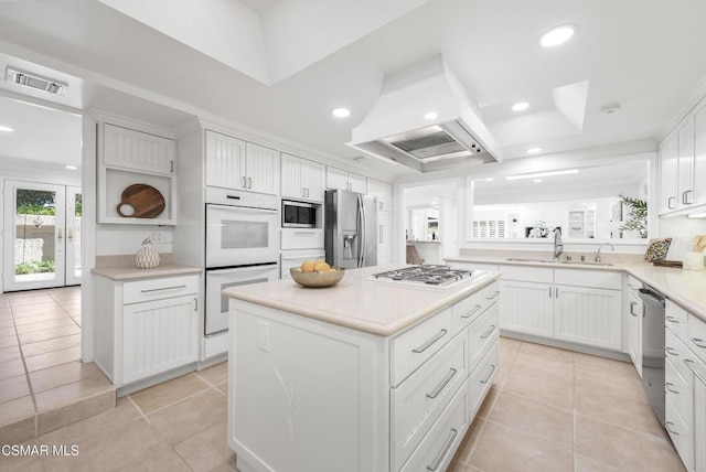 kitchen featuring a center island, extractor fan, white cabinetry, stainless steel appliances, and sink