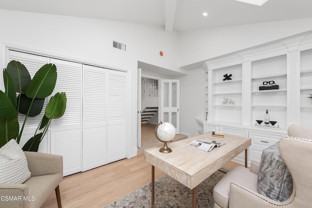 office area with light hardwood / wood-style floors and lofted ceiling with beams