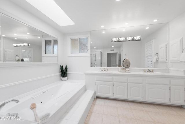 bathroom with vanity, a skylight, tile patterned floors, and separate shower and tub