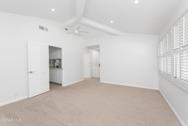 carpeted spare room with ceiling fan and vaulted ceiling with beams