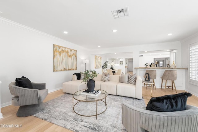 living room featuring crown molding and light hardwood / wood-style floors