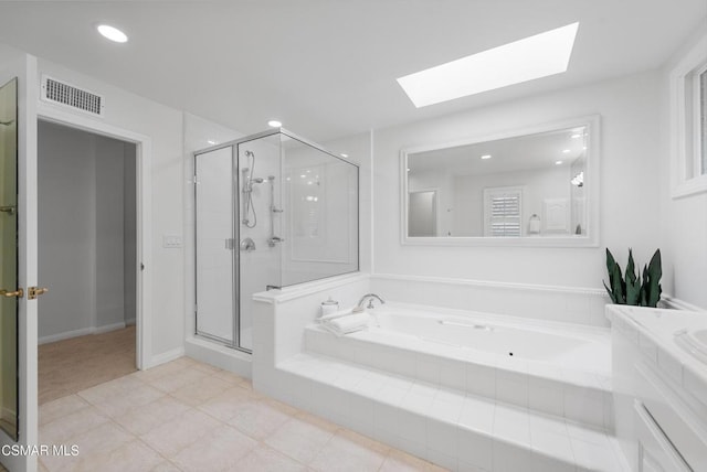 bathroom featuring tile patterned flooring, shower with separate bathtub, a skylight, and vanity