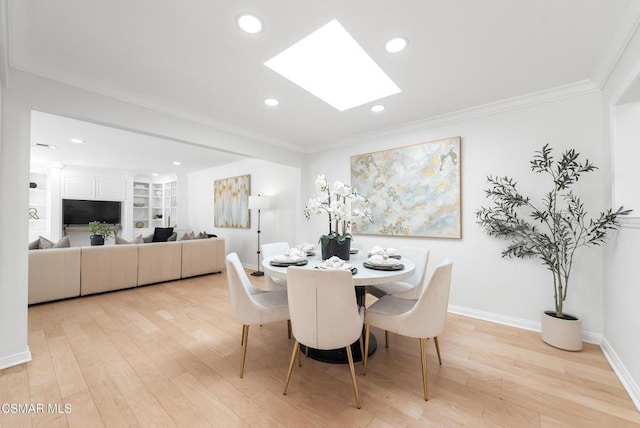 dining space with built in shelves, light hardwood / wood-style flooring, a skylight, and crown molding