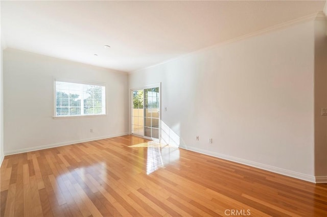 empty room featuring ornamental molding and light wood-type flooring