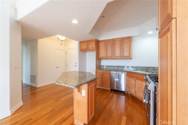 kitchen featuring sink, a kitchen island, stainless steel appliances, dark hardwood / wood-style floors, and a kitchen bar