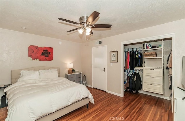 bedroom featuring ceiling fan, a textured ceiling, a closet, and dark hardwood / wood-style flooring