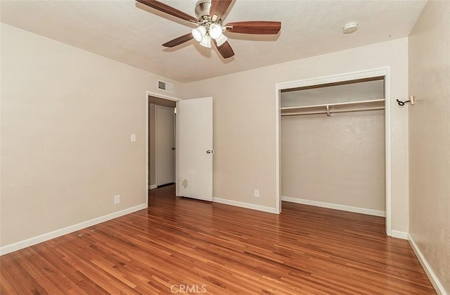 unfurnished bedroom with ceiling fan, wood-type flooring, and a closet