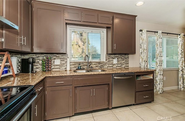 kitchen featuring dishwasher, sink, range with electric cooktop, light tile patterned floors, and light stone counters