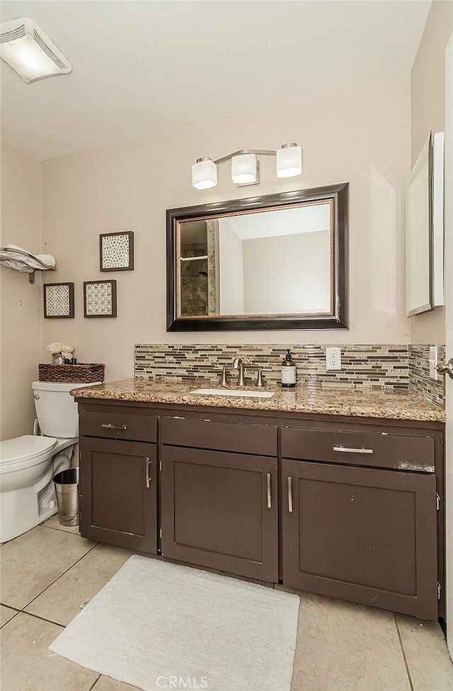 bathroom with toilet, vanity, decorative backsplash, and tile patterned floors