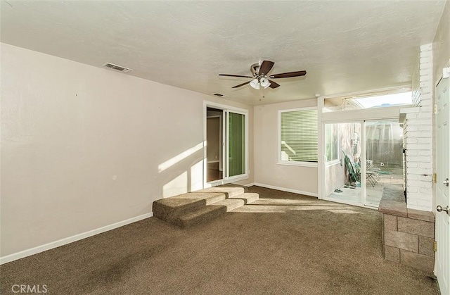 carpeted spare room with ceiling fan and a textured ceiling