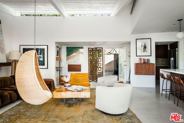 living room with a wealth of natural light, concrete floors, and beamed ceiling