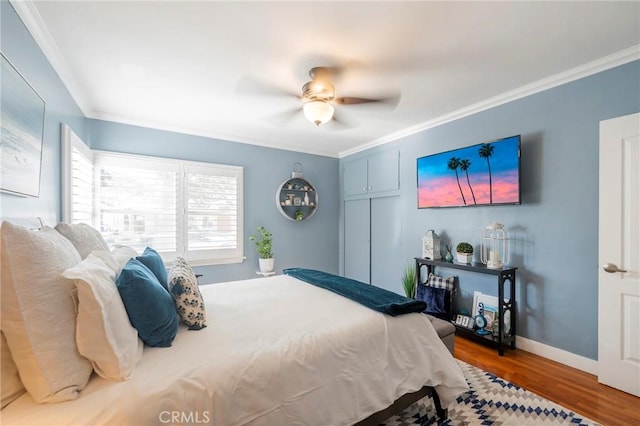 bedroom featuring ceiling fan, ornamental molding, and hardwood / wood-style flooring