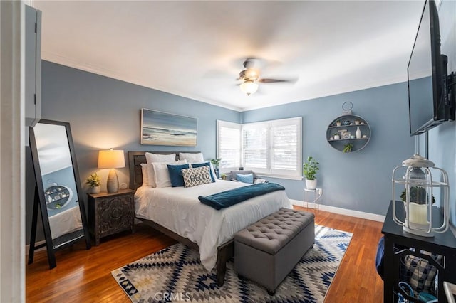 bedroom with ceiling fan, wood-type flooring, and crown molding