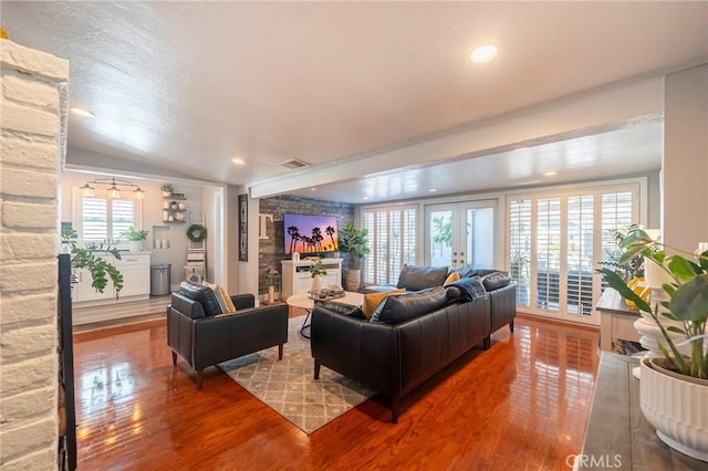 living room featuring vaulted ceiling and hardwood / wood-style flooring