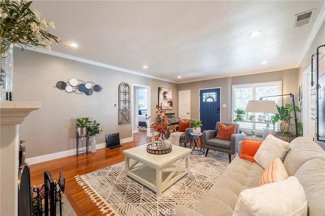 living room featuring a fireplace, crown molding, and hardwood / wood-style floors