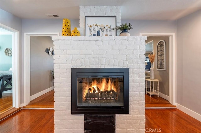 interior details with wood-type flooring and a fireplace