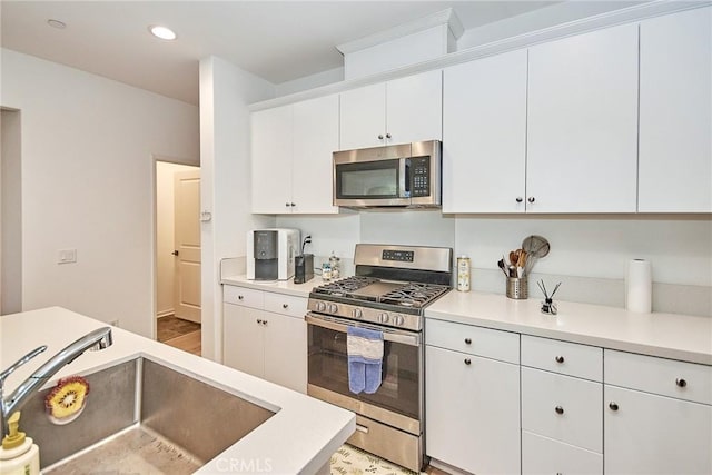 kitchen featuring white cabinets, appliances with stainless steel finishes, and sink