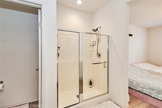 bathroom with an enclosed shower and wood-type flooring