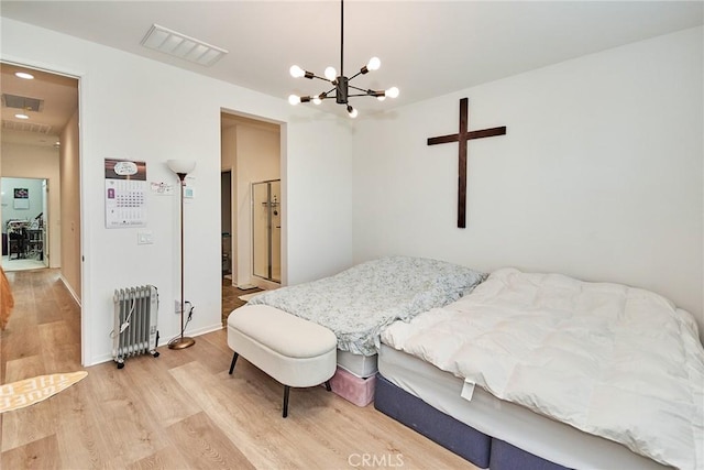 bedroom with a chandelier, hardwood / wood-style flooring, and radiator heating unit