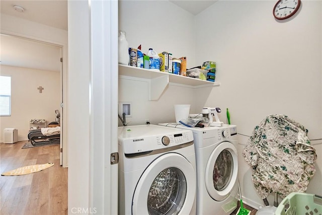 clothes washing area with separate washer and dryer and hardwood / wood-style flooring