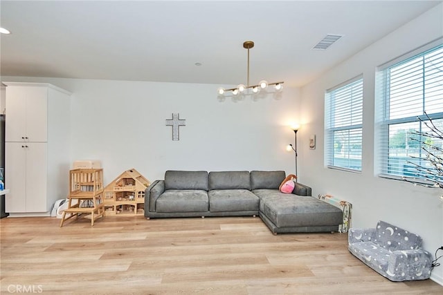 living room featuring an inviting chandelier and light wood-type flooring