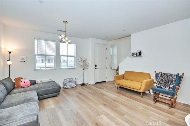 living room with light hardwood / wood-style floors and a chandelier