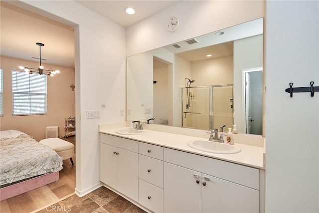 bathroom with walk in shower, a notable chandelier, and vanity