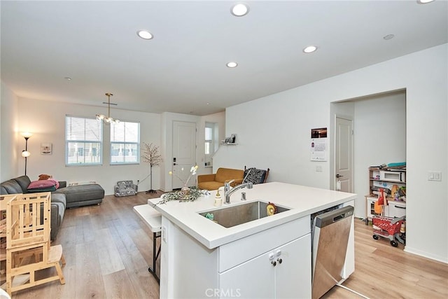 kitchen with white cabinetry, an island with sink, decorative light fixtures, dishwasher, and sink