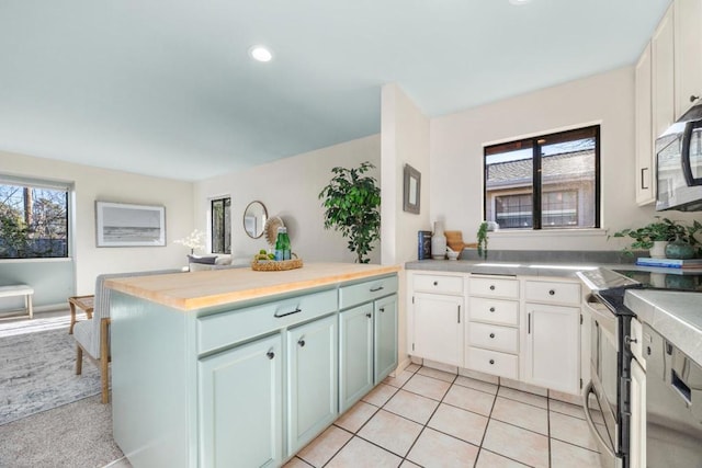 kitchen featuring electric stove, a wealth of natural light, and white cabinets