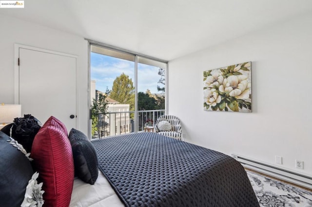 bedroom with access to outside, a wall of windows, and a baseboard radiator