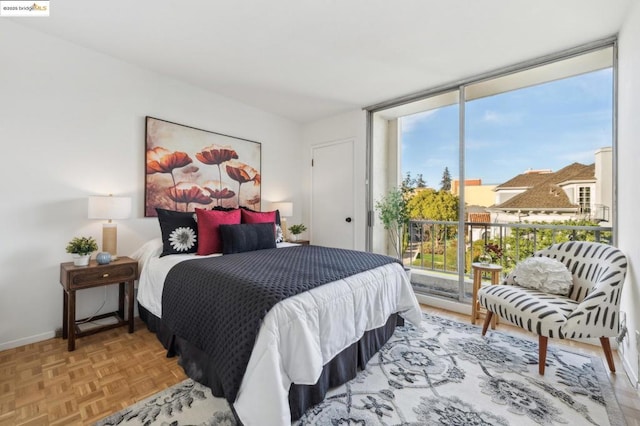 bedroom featuring a wall of windows and light parquet floors