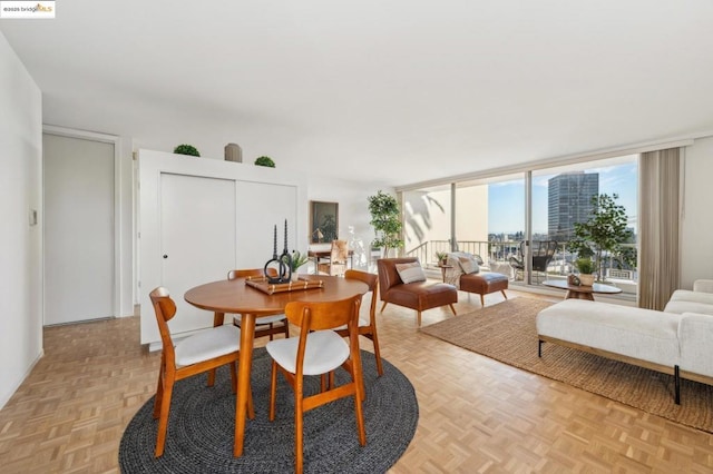 dining space featuring light parquet flooring and a wall of windows