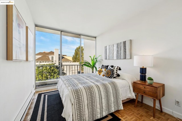 bedroom with a baseboard heating unit, access to exterior, a wall of windows, and parquet floors