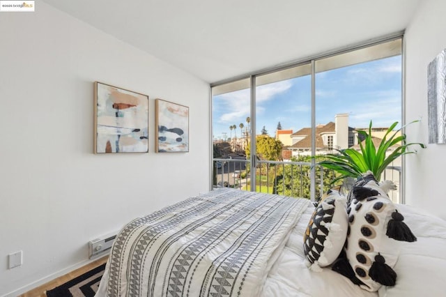 bedroom with access to exterior and hardwood / wood-style flooring