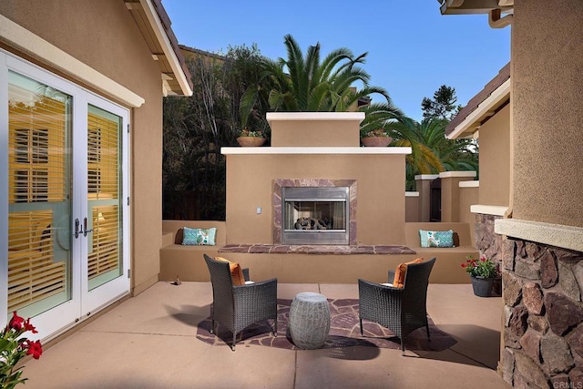 view of patio with a premium fireplace and french doors