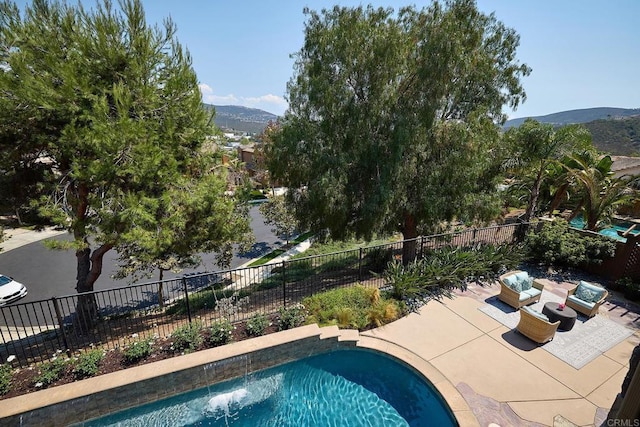 view of pool with fence, a mountain view, and a patio