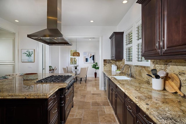 kitchen with light stone counters, stone tile floors, a sink, decorative backsplash, and island exhaust hood