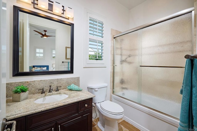 bathroom with ceiling fan, bath / shower combo with glass door, vanity, and toilet