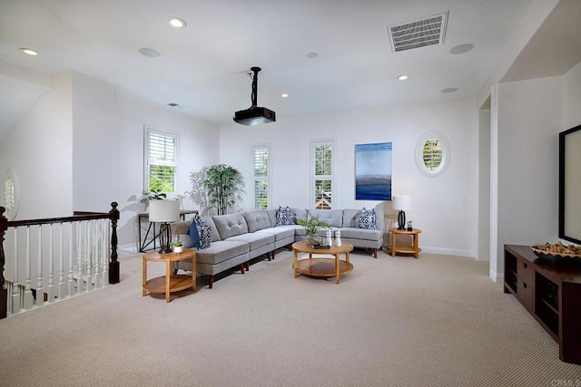 living area with recessed lighting, visible vents, baseboards, and light colored carpet